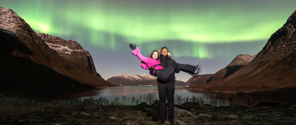 A couple under the northern lights by a fjord near Tromsø