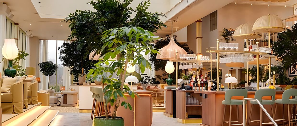 Bright lounge and bar with plants at Hjortviken Country Club